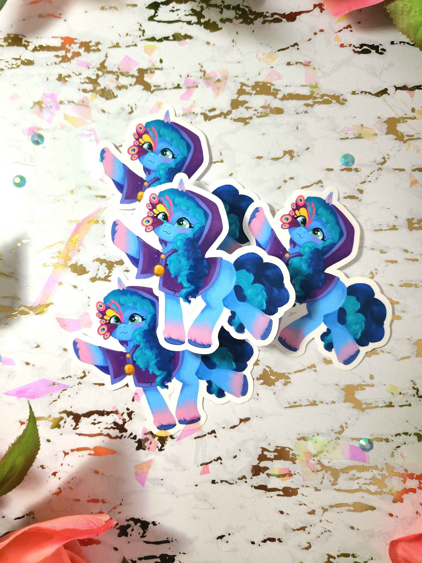 Colorful cartoon pony stickers on a textured surface with colorful confetti.