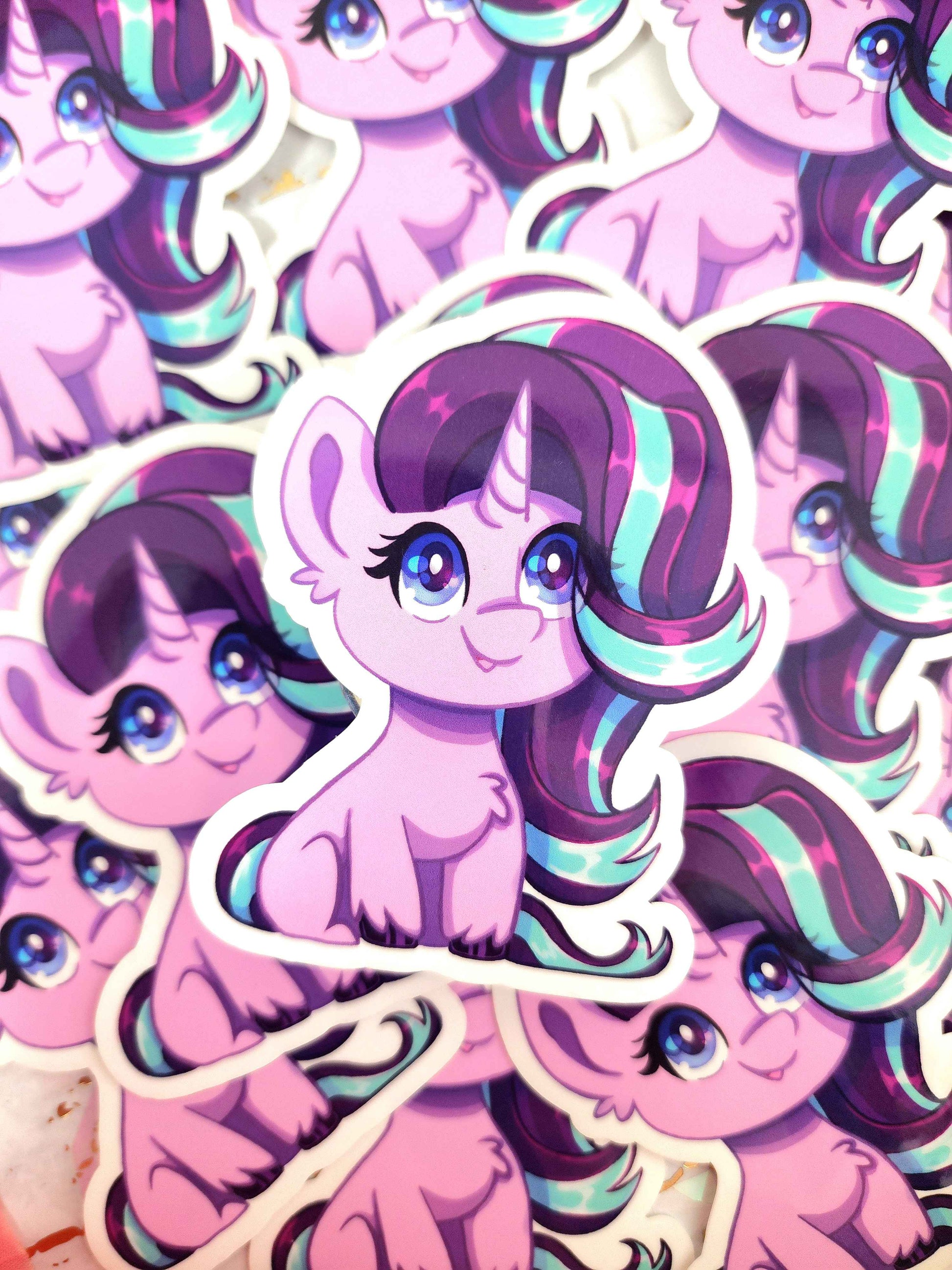 Sticker of a pink pony with purple and teal hair on a matching pink background
