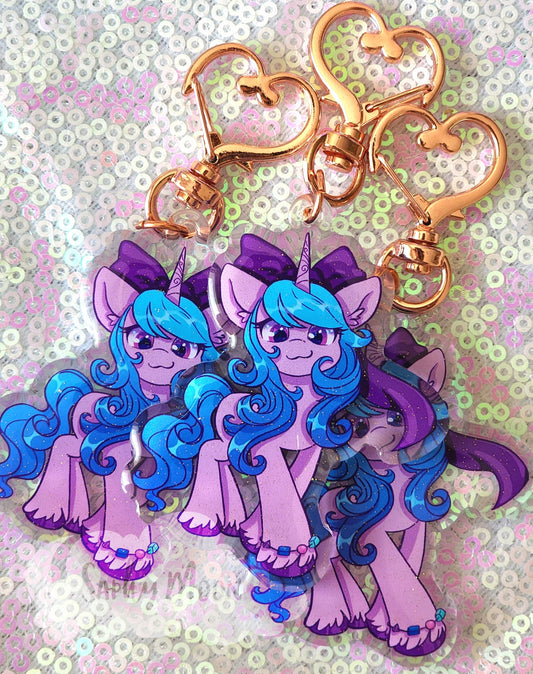 Keychain with purple and blue unicorn design on a glittery background