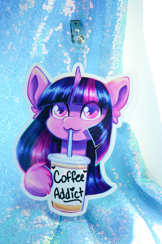 Sticker of a character with purple hair and ears holding a 'Coffee Addict' cup on a blue glittery background.